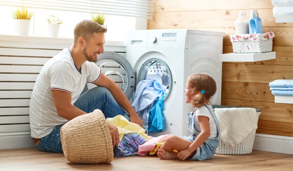 mężczyzna robiący pranie z córką